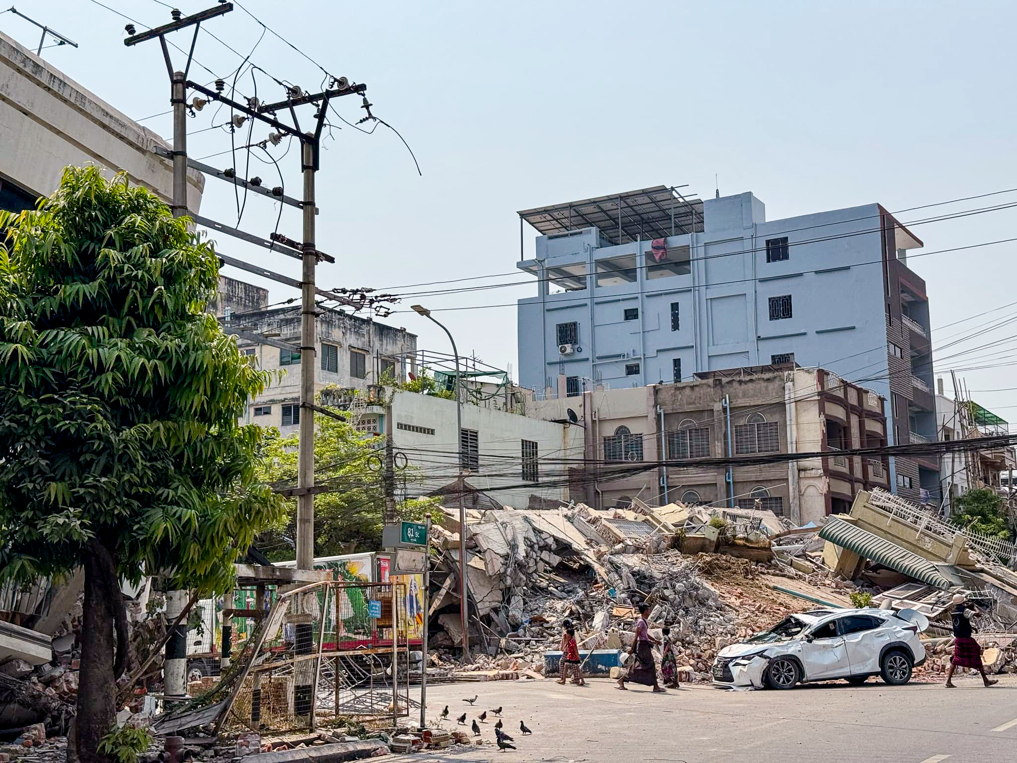 Urban scene, with destroyed building in background.