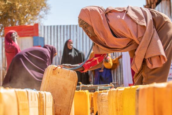 A women collecting water in jerrycans.