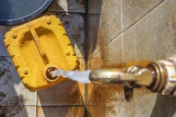 A jerry can being filled at a water access point.
