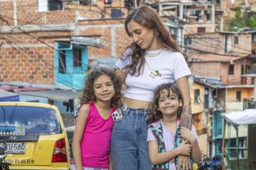 Colombian mother with daughters in urban scene.