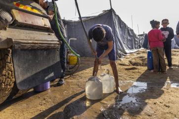Palestinian children collecting water.