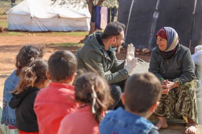 A displaced person speaking with a mercy corps staff member.