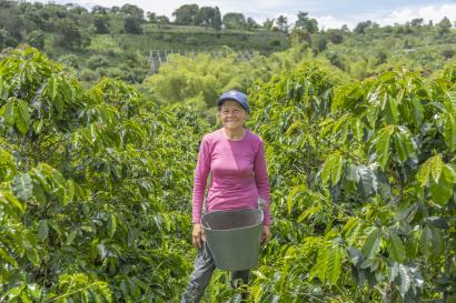 Colombian woman stands in middle of an agriu
