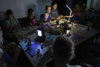 A group of people attending an art therapy session during a blackout.