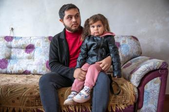 A man and his daughter sit at home in ukraine