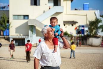Baby on shoulders of smiling man in greece