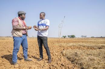 Two people having a conversation in a field.