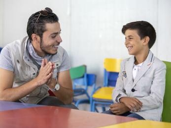 At a youth center in zaatari, omar al-tal sits with mohammad. mohammad is able to play sports and games while learning important life skills like computers and english. two of mohammad’s favorite activities are playing foosball and soccer, but his favorite is singing. at a recent talent show in the center, he finished third. photo: ezra millstein/mercy corps